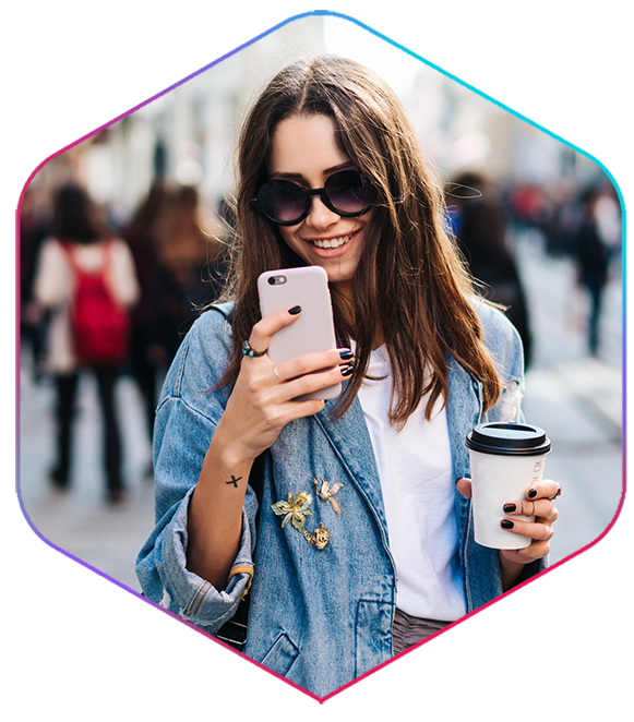 girl looking at iPhone with coffee cup in hand