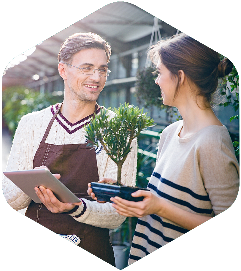 home and garden employee helping a customer holding a plant